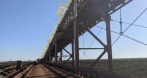 Rising profile of conveyors at seaward end near transfer tower requiring craneage.